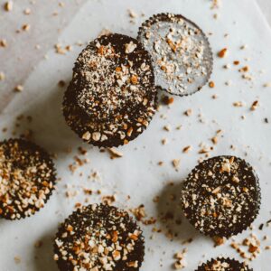 Top view of dark chocolate bites sprinkled with almonds on parchment paper.